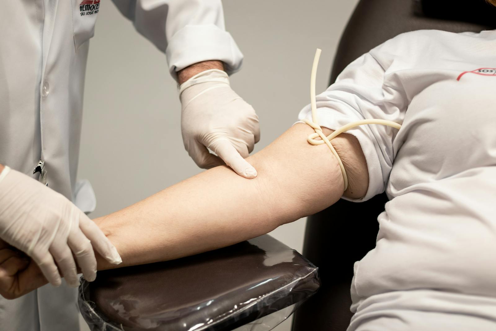 A Medical Professional Wearing Latex Gloves Holding a Person's Hand